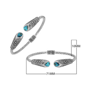 Sterling silver twisted bangle with blue topaz quartz ends and Balinese oxidized dot pattern