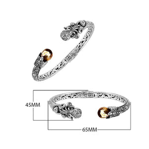 A wholesale sterling silver octopus bangle featuring a warm citrine quartz stone, artistic tentacle engravings, oxidized Balinese textures, and a secure hinge lock mechanism.