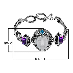Sterling Silver bracelet featuring a carved bone face centerpiece, Garnet Quartz and Blue Topaz Quartz stones, detailed scroll panels, and a secure toggle lock for wholesale assortments.