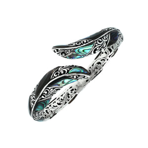 Wholesale sterling silver feather-inspired bangle featuring iridescent Abalone Shell inlays, ornate Balinese scroll engravings, and a secure hinge lock for premium artisan-style jewelry collections.