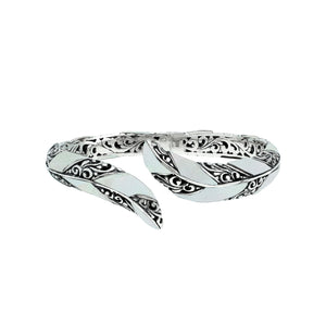 Wholesale sterling silver feather-inspired bangle featuring Mother Of Pearl inlays, ornate Balinese scroll engraving, and a secure hinge lock for premium artisan-style jewelry assortments.
