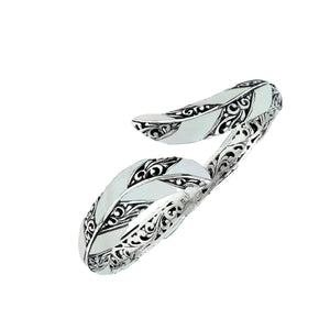 Wholesale sterling silver feather-inspired bangle featuring Mother Of Pearl inlays, ornate Balinese scroll engraving, and a secure hinge lock for premium artisan-style jewelry assortments.