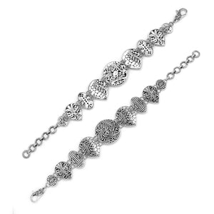 Wholesale sterling silver link bracelet featuring multiple carved Balinese motif shapes, intricate scroll engravings, and a secure lobster lock for premium artisan jewelry assortments.