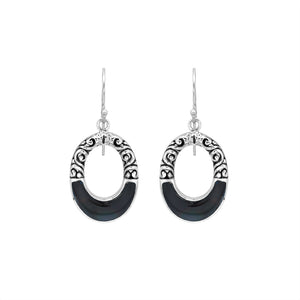 Sterling silver oval drop earrings featuring glossy Black Shell inlay, open center silhouette, sculpted scroll motifs, oxidized detailing, polished borders, and French ear wires.