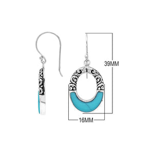 Sterling silver oval drop earrings featuring vibrant Turquoise Shell inlay, open center silhouette, sculpted scroll motifs, oxidized detailing, polished borders, and French ear wires.