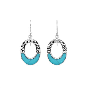 Sterling silver oval drop earrings featuring vibrant Turquoise Shell inlay, open center silhouette, sculpted scroll motifs, oxidized detailing, polished borders, and French ear wires.