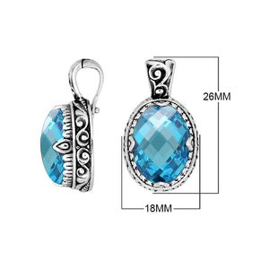 Sterling silver oval pendant featuring a vibrant Blue Topaz Quartz center decorated with intricate Balinese scroll carvings and a smooth, polished artistic frame.