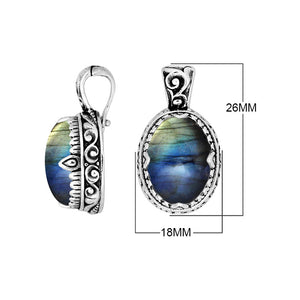 Sterling silver oval pendant featuring a vivid Ruby Quartz centerpiece highlighted by detailed Balinese scroll carvings and a smoothly polished artistic frame design.