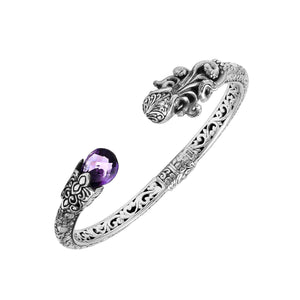 A wholesale sterling silver octopus-inspired bangle featuring a vivid amethyst quartz stone, intricate Balinese carvings, oxidized detailing, and a secure hinge lock mechanism ideal for bulk jewelry buying.