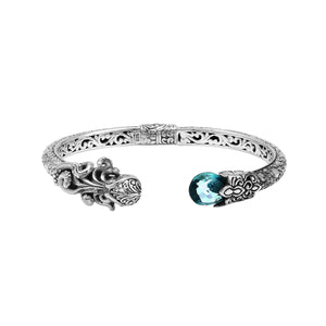 A wholesale sterling silver octopus-themed bangle featuring blue topaz quartz, detailed tentacle carvings, oxidized textures, and a secure hinge lock ideal for bulk jewelry purchases.