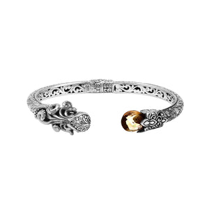 A wholesale sterling silver octopus bangle featuring a warm citrine quartz stone, artistic tentacle engravings, oxidized Balinese textures, and a secure hinge lock mechanism.