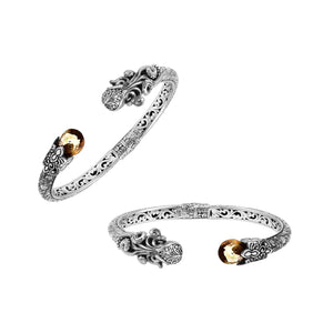 A wholesale sterling silver octopus bangle featuring a warm citrine quartz stone, artistic tentacle engravings, oxidized Balinese textures, and a secure hinge lock mechanism.