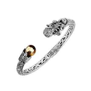 A wholesale sterling silver octopus bangle featuring a warm citrine quartz stone, artistic tentacle engravings, oxidized Balinese textures, and a secure hinge lock mechanism.