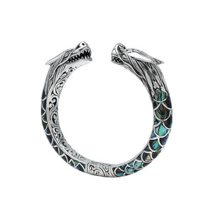 Wholesale sterling silver phoenix cuff bangle featuring Abalone Shell accents, intricate Balinese scroll engraving, and a secure hinge lock for detailed artisan presentation.