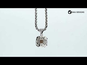 Sterling silver cushion pendant featuring a faceted Smokey Quartz centerpiece secured with decorative prong detailing and traditional Balinese carved ornamentation.