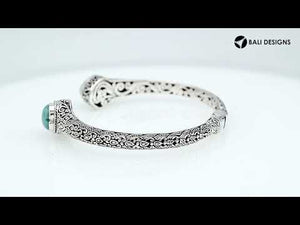 Wholesale sterling silver bangle featuring Larimar double-end stones, ornate Balinese scroll engravings, and a secure hinge lock for artisan-quality jewelry collections.