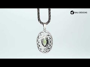 Handcrafted sterling silver pendant with Peridot Quartz in an oval Balinese filigree frame and polished silver finish.