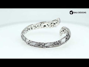 Wholesale sterling silver feather-inspired bangle featuring Mother Of Pearl inlays, ornate Balinese scroll engraving, and a secure hinge lock for premium artisan-style jewelry assortments.