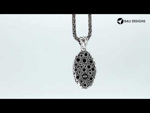Wholesale sterling silver oval pendant with abstract carved black pattern.