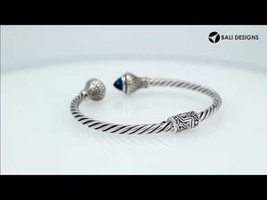 Wholesale sterling silver twisted cable cuff bracelet with faceted blue topaz quartz end caps, hinge lock, and ornate Balinese engravings for premium jewelry collections.