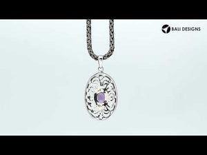 A handcrafted sterling silver pendant featuring a radiant Amethyst Quartz centered in a detailed Balinese filigree oval frame.