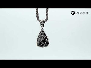Sterling silver teardrop pendant with raised droplet motif and Bali swirl carvings, handcrafted in Bali.
