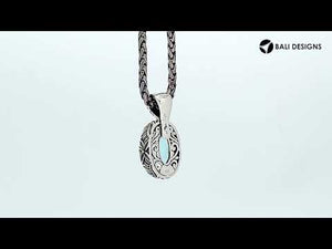 Sterling silver oval-shaped Blue Topaz Quartz pendant with floral detailing and enhancer bail, polished for brilliance and ideal for wholesale jewelry collections and catalogs.