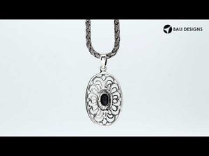 A handcrafted sterling silver pendant featuring a faceted Black Onyx in an elegant oval Balinese filigree frame.