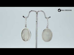 Wholesale sterling silver earrings featuring oval mother of pearl drops with polished wave-motif overlay, crafted for consistent quality, catalog readiness, and elegant presentation suitable for bulk jewelry sourcing.