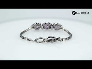 Wholesale sterling silver bracelet featuring three vibrant Amethyst Quartz stones framed in ornate Balinese settings with a woven chain and secure toggle lock for catalog-ready presentation.