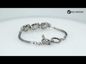 Wholesale sterling silver bracelet featuring three bright Blue Topaz Quartz stones framed in detailed Balinese settings with woven chain segments and a secure toggle lock.