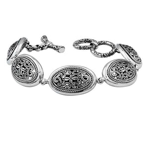 Sterling Silver oval link bracelet featuring detailed scroll pattern panels and a secure toggle lock, designed for wholesale buyers needing refined craftsmanship and durability.