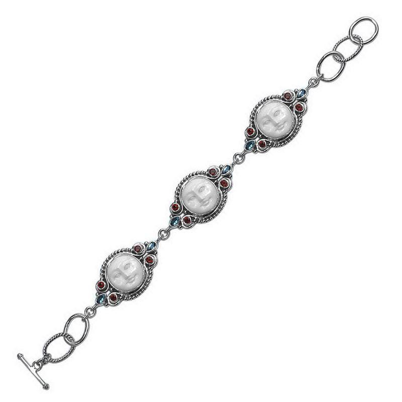 Sterling silver bracelet featuring carved bone faces with Garnet Quartz and Blue Topaz Quartz accents and an artisan toggle lock.