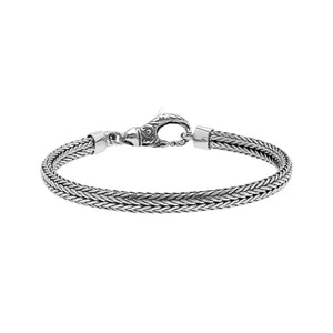 A beautifully crafted sterling silver woven bracelet with a secure lobster clasp, featuring intricate chain detailing and a mirror-polished high-gloss finish for elegant collections.