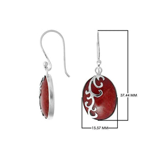 Wholesale sterling silver earrings featuring oval red coral drops with a polished wave-motif overlay, offering reliable craftsmanship and elegant presentation suitable for bulk jewelry orders.