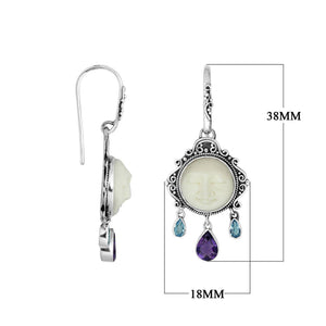 Wholesale sterling silver earrings featuring a carved bone face framed by ornate Balinese detailing, accented with blue topaz quartz and an amethyst quartz drop for consistent artisan-quality presentation.