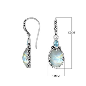 Wholesale sterling silver earrings featuring a glowing Rainbow Moonstone drop paired with a bright Blue Topaz Quartz accent and ornate carved borders for premium presentation.