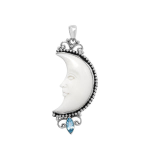 Sterling silver crescent moon pendant with carved bone face and marquise blue topaz gemstone, Balinese artisan jewelry.
