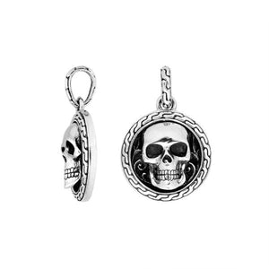 Sterling silver round skull pendant with carved texture and polished detailing.