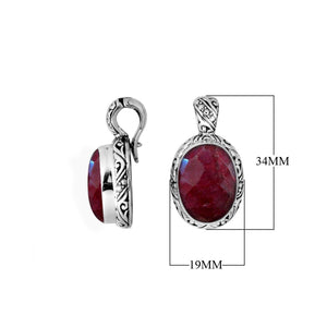 Sterling silver pendant featuring an oval Ruby Quartz set in a carved Balinese patterned frame with polished shine.