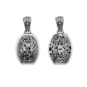 A wholesale Silver Overlay Over Copper oval pendant featuring detailed Balinese scrollwork, oxidized antique textures, polished overlay accents, and traditional filigree artistry ideal for bulk jewelry buyers.