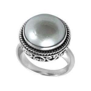 Wholesale sterling silver mother of pearl ring with polished cabochon stone, rope bezel, and Balinese scroll detailing – handcrafted artisan jewelry from Bali.