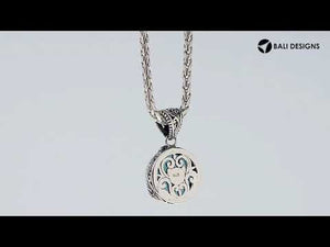 A beautifully handcrafted 925 sterling silver pendant showcasing a round faceted Blue Chalcedony Quartz stone surrounded by traditional Balinese patterns and ornate engraved details on the frame.