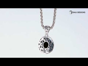 A wholesale sterling silver and 18K gold oval halo pendant featuring a hammered gold center, diamond accents, and detailed Balinese engraving with oxidized textures ideal for bulk jewelry buyers.