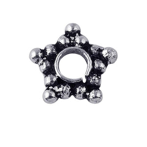 Star-shaped granulated spacer bead in silver overlay over copper with oxidized detailing and open circular center.