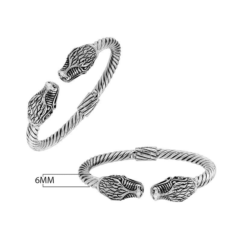 Sterling silver twisted bangle with dragon face design and oxidized Balinese pattern