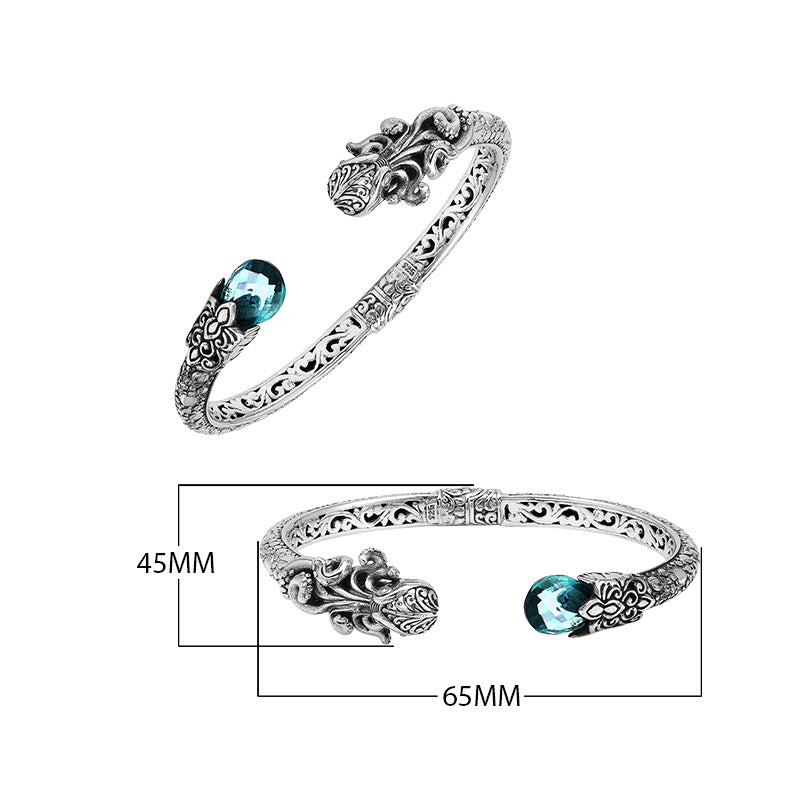 A wholesale sterling silver octopus-themed bangle featuring blue topaz quartz, detailed tentacle carvings, oxidized textures, and a secure hinge lock ideal for bulk jewelry purchases.