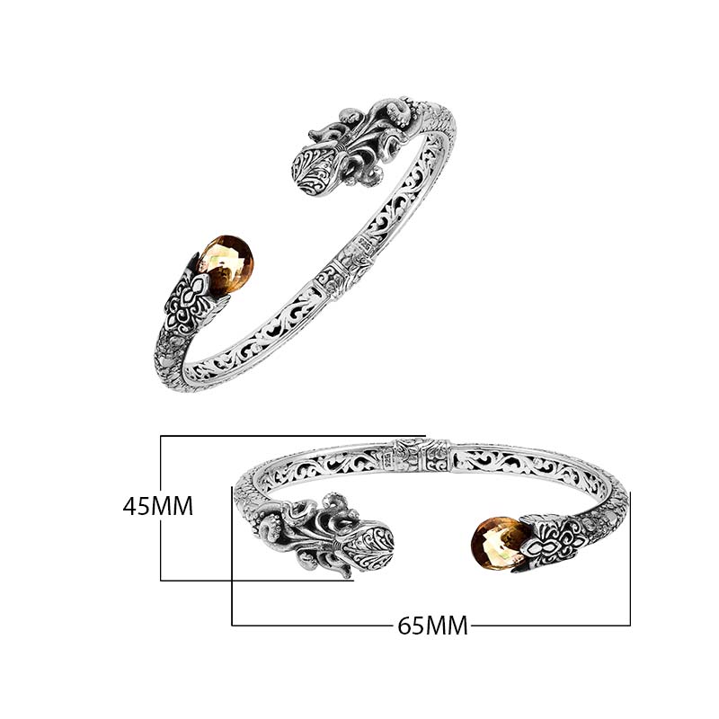 A wholesale sterling silver octopus bangle featuring a warm citrine quartz stone, artistic tentacle engravings, oxidized Balinese textures, and a secure hinge lock mechanism.