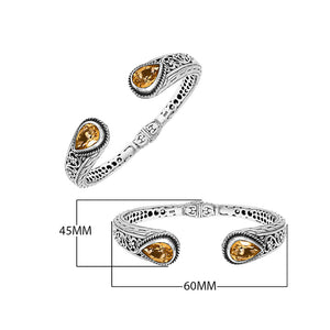 Sterling silver bangle featuring teardrop citrine quartz stones, ornate Bali engraving, oxidized accents, and a secure hinge lock made for premium wholesale jewelry collections.