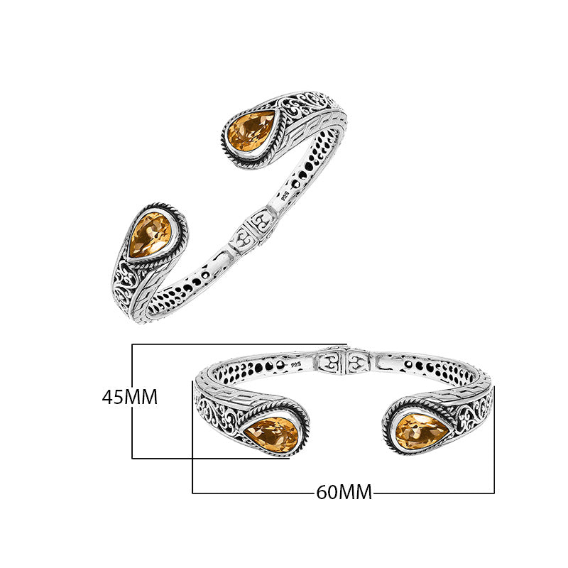 Sterling silver bangle featuring teardrop citrine quartz stones, ornate Bali engraving, oxidized accents, and a secure hinge lock made for premium wholesale jewelry collections.